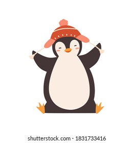 Funny baby penguin enjoying winter season vector flat illustration. Happy polar bird wearing chullo hat with pompom isolated on white. Adorable childish animal character in warm headwear