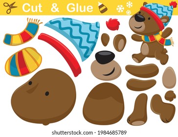 Funny bear wearing winter hat and scarf. Education paper game for children. Cutout and gluing. Vector cartoon illustration