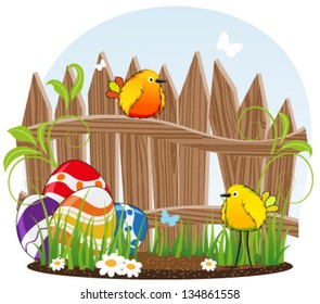 Funny birds with Easter eggs on the background of the wooden fence