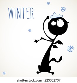 Funny black cat surprised by snowflakes falling, room for your text.