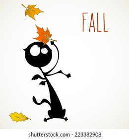 Funny black cat surprised by autumn falling leaves. room for your text.