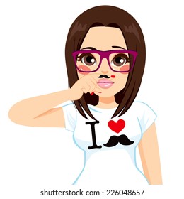 Funny brunette hipster girl making faces pretending to have fake mustache in finger wearing white shirt with I love mustache print design and glasses