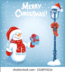 Funny cartoon snowman with gift box on background of Christmas snowfall, street lamp and inscription "Merry Christmas"
