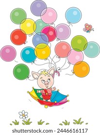 Funny cartoony little piglet flying in an umbrella with colorful toy balloons and merry butterfly over a green summer lawn, vector cartoon illustration on a white background