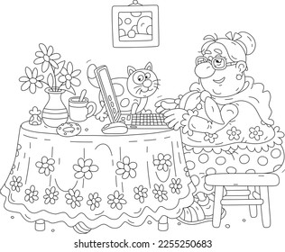 Funny chubby granny and her merry cat sitting at their beautiful kitchen table with a laptop, browsing pages on Internet and chatting with friends in social networks and messengers