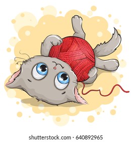 Funny gray kitten playing with a ball of yarn. Background yellow