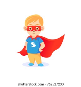 Funny little boy in superhero pose wearing red mask and red cape