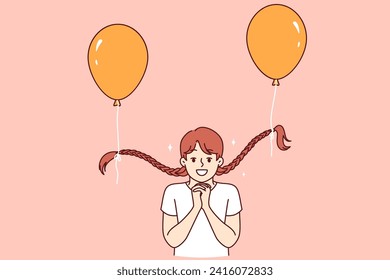 Niña divertida con globos atados a trenzas dobla las palmas, pidiendo o mostrando esperanza. Niña alegre experimentando felicidad y serenidad disfrutando jugando con globos