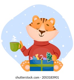 Funny little happy tiger cub dressed in a warm sweater drinks hot tea with sweet candy . Vector character illustration in flat style. Winter holidays concept.
