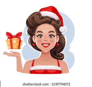 Gracioso retrato de un retro sonriente enganchando belleza con una caja de regalo de Navidad con un sombrero de Papá Noel.