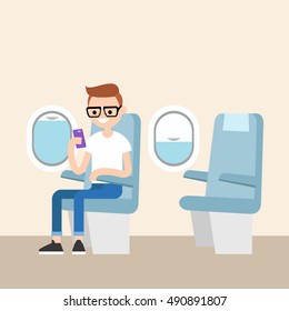 Funny red head nerd sitting on the plane and holding his smart phone / editable flat vector illustration