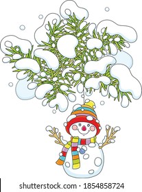 Funny toy snowman with a colorful striped scarf and a warm hat hanging on a snowy prickly fir branch of a decorated Christmas tree, vector cartoon illustration isolated on a white background