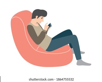 Gadget dependence.  Young man sitting on couch with smartphone.