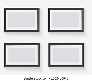 Gallery interior with four empty frames on wall.
