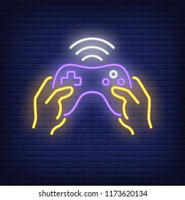 Game controller neon icon. Hands holding wireless joystick on brick wall background. Gaming industry concept. Vector illustration can be used for neon signs, billboards, video game arcades promo.