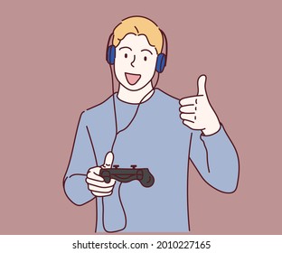 Gamer man with beard playing video game using joystick and headphones happy with big smile doing ok sign, thumb up with fingers. Hand drawn in thin line style, vector illustrations.