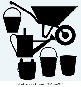 Garden wheelbarrow, watering can and buckets. Isolated on blue background. Vector silhouettes