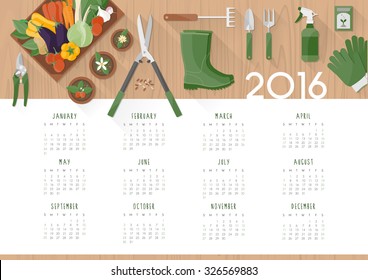 Gardening calendar 2016 with work tools, flower pots and vegetables in a crate on a  wooden table, top view