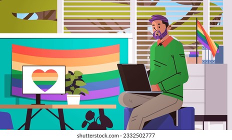 gay sitting at workplace and using laptop lgbt rainbow flag transgender love generation Z concept office interior