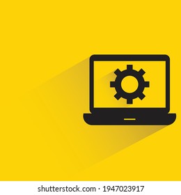 gear in laptop with shadow on yellow background