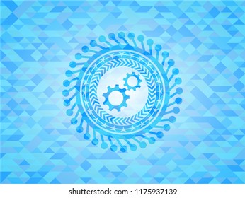 gear, team work icon inside light blue emblem with triangle mosaic background