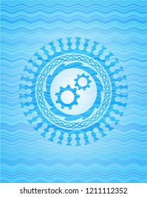 gear, team work icon inside water wave representation emblem.