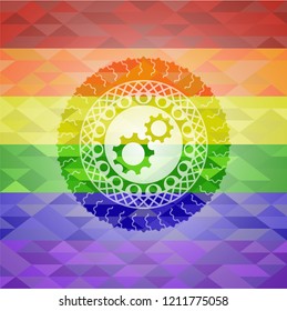 gear, team work icon inside emblem on mosaic background with the colors of the LGBT flag