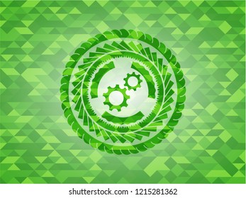 gear, team work icon inside green emblem with mosaic ecological style background