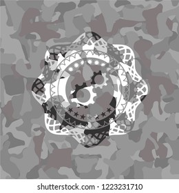 gear, team work icon inside grey camo emblem