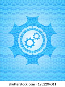 gear, team work icon inside light blue water wave emblem.