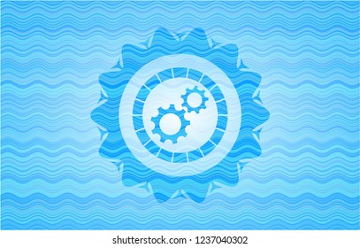 gear, team work icon inside light blue water badge background.