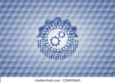 gear, team work icon inside blue emblem with geometric pattern.