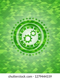 gear, team work icon inside green emblem with triangle mosaic background