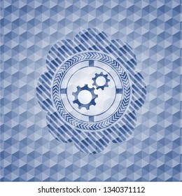 gear, team work icon inside blue emblem or badge with geometric pattern background.