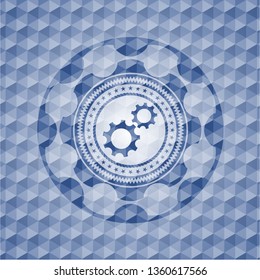 gear, team work icon inside blue badge with geometric pattern.