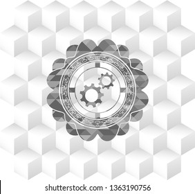 gear, team work icon inside grey badge with geometric cube white background