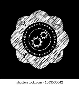 gear, team work icon inside chalk emblem written on a blackboard