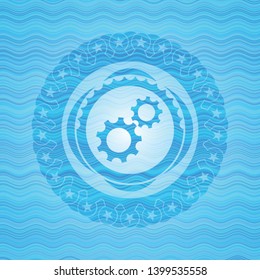 gear, team work icon inside light blue water wave emblem background.