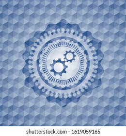 gear, team work icon inside blue emblem with geometric pattern.