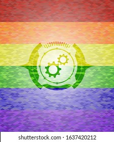 gear, team work icon inside emblem on mosaic background with the colors of the LGBT flag
