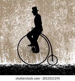 A gentleman in a top hat on a vintage high bicycle against the background of the grunge texture of the old wall.