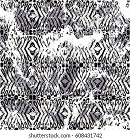 Geometric grunge pattern in black and white on colorful hand painted background. Bold print with stripes and shapes on paint splatters and splashes. Vintage texture with ethnic and tribal motifs