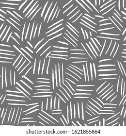 Geometric seamless pattern from white strokes and stripes on a gray background Repeating chaotic short lines. Filled space pattern background. Vector stock illustration on a gray background.hand-drawn