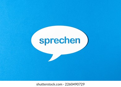 German word speak in a speech bubble punched out of paper on blue background. Photorealistic vector. 
