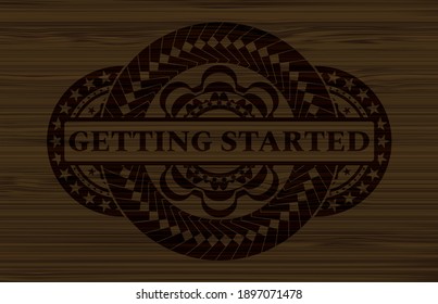 Getting Started text inside dark wood realistic badge. Brown graceful background. Artistic illustration. 