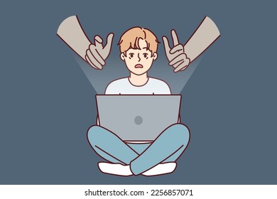 Giant hands reaching out to teenage boy using laptop with internet without parental control. concept of danger of using gadgets by children due to possibility of identity theft