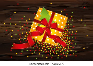Gift box with a bow and a Christmas tree. View from above. Confetti multicolored in the form of stars. Greeting card or invitation for a holiday on a wooden background.