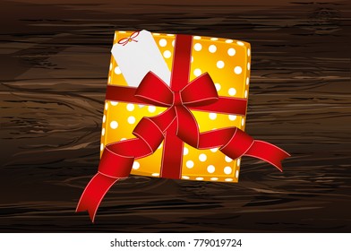 Gift box with a bow for Valentine's Day or Birthday. Free note form for text. View from above. Greeting card or invitation on a wooden background