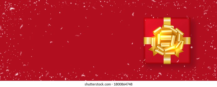 Gift box decorated with gold bow isolated on red background with snowfall around. Christmas and New Year banner.  Top view.Copy space. Xmas holiday. Vector illustration.