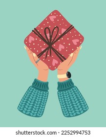 Caja de regalo en mano. Un regalo envuelto en un envoltorio de papel festivo con una proa atada, cinta, cordón, cuerda. Navidad, Navidad, Día de San Valentín, cumpleaños y Año Nuevo presentes en papel envolvente en las manos.